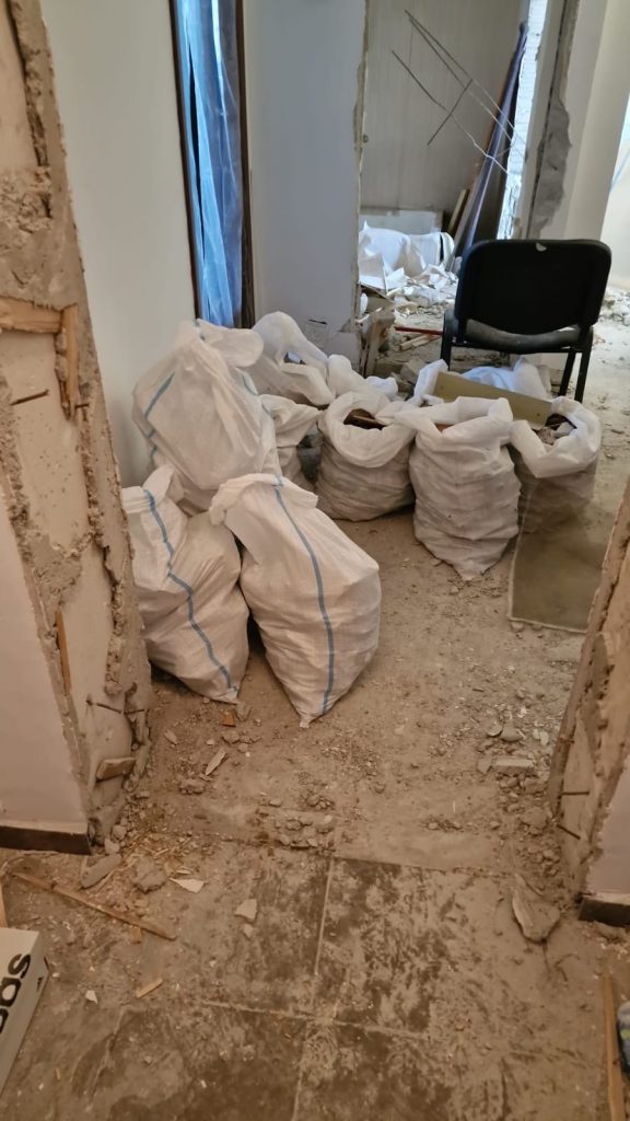 Imagine cu echipament de demolare și saci de moloz